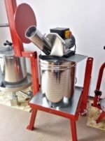 Electric apple mill sitting on top of a fruit press